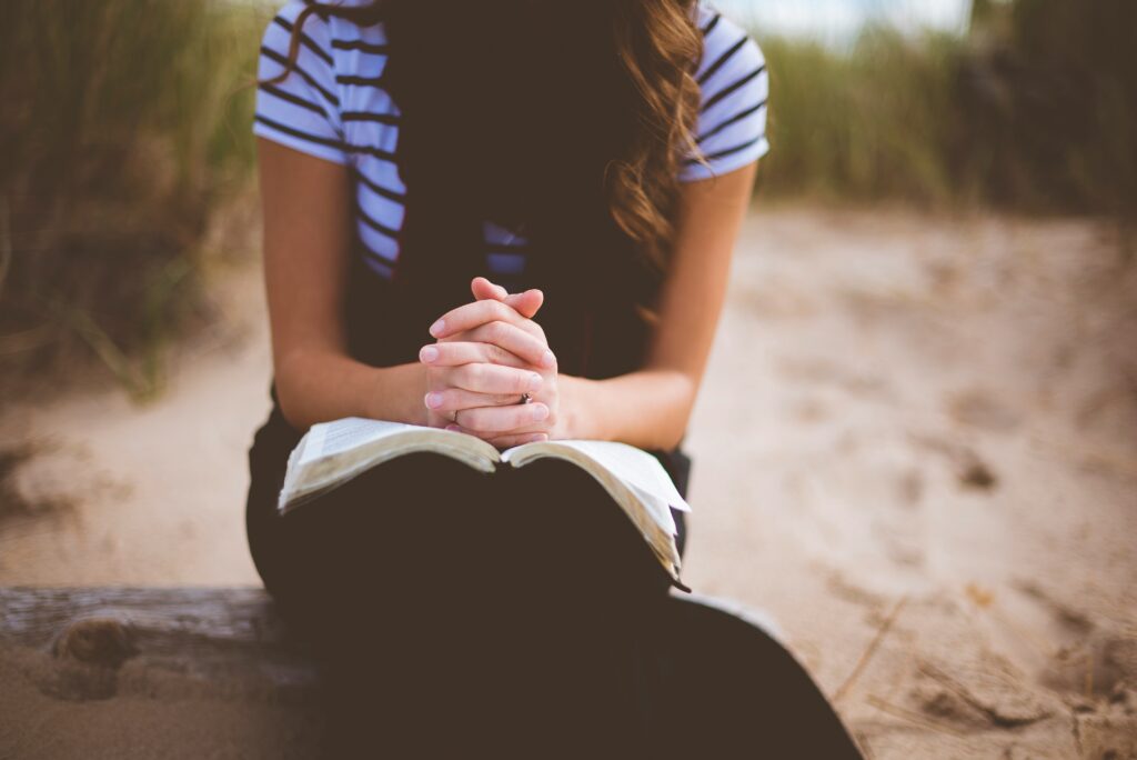 woman praying with Bible in her lap